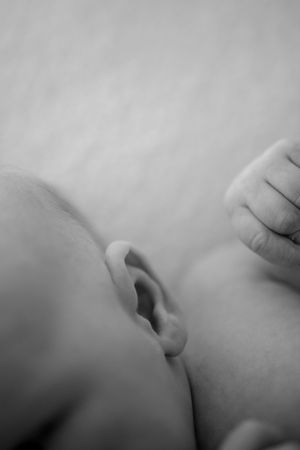 Gentle black and white profile silhouette showing soft infant features against light background.
