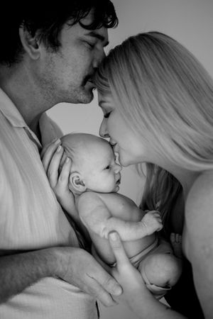 Black and white series capturing tender family moments with a newborn.