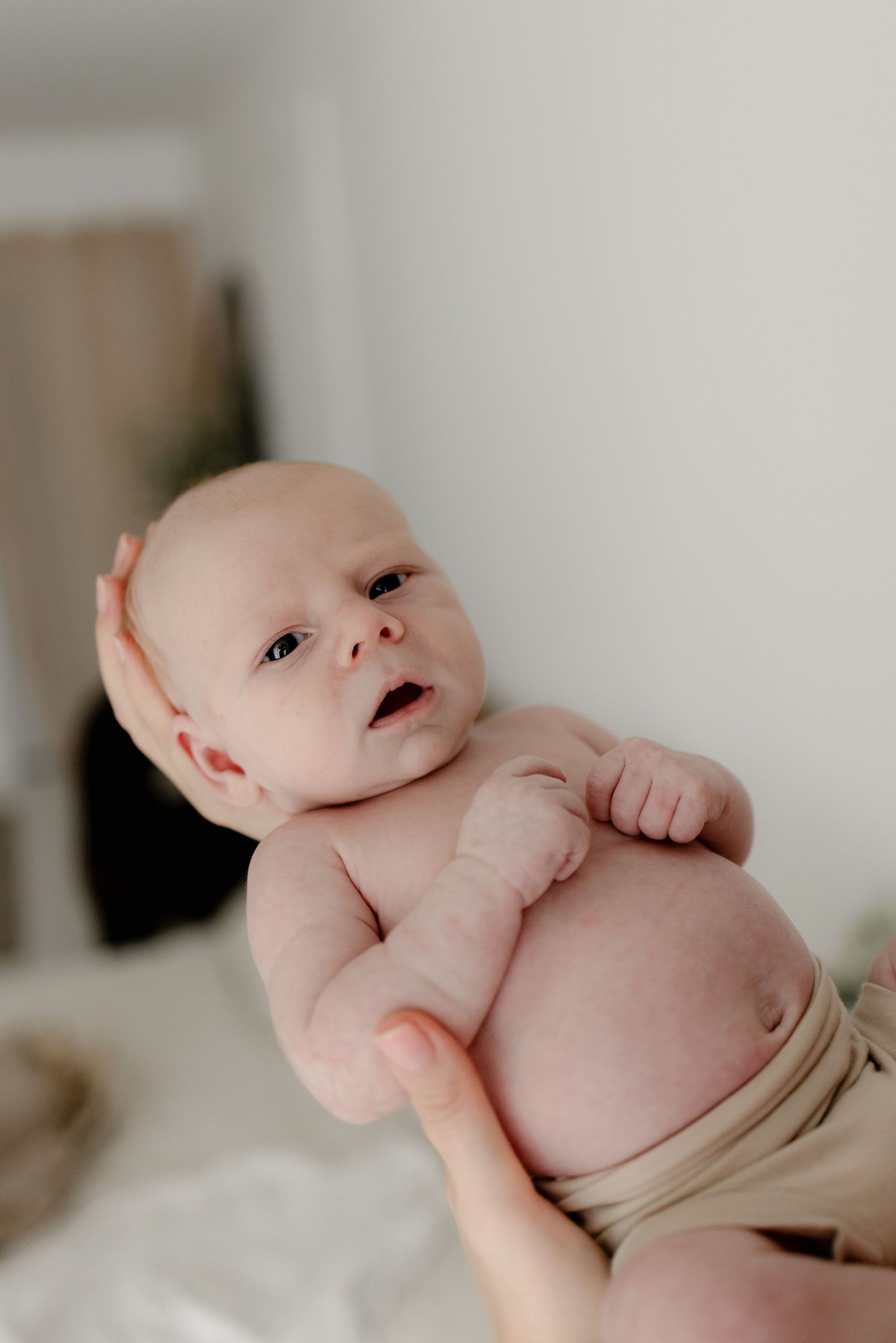 Close-up shots of a newborn baby with expressive facial features against white background.