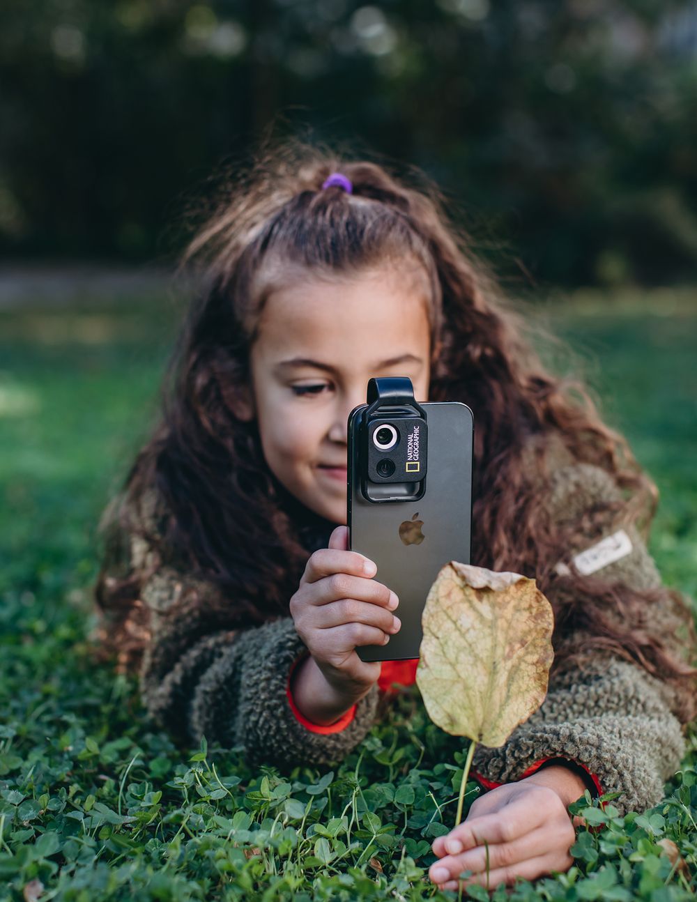 A sequence of photos showing someone lying in grass while taking photos with a smartphone camera.