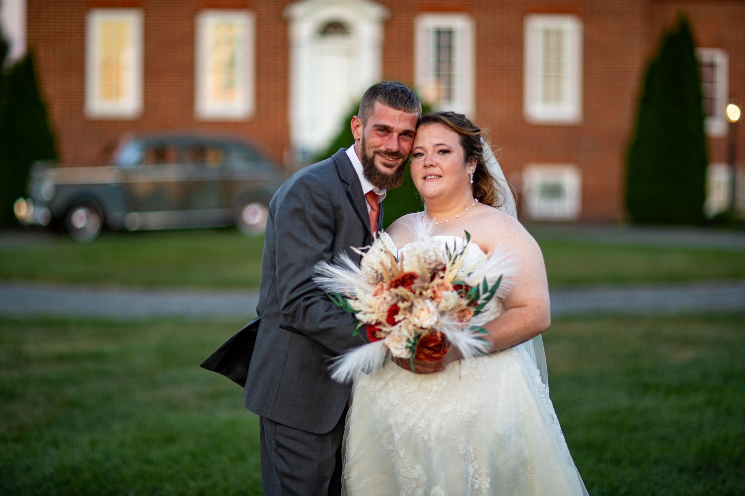 frederick maryland wedding photographer A joyful wedding portrait in front of a classic brick building at sunset.