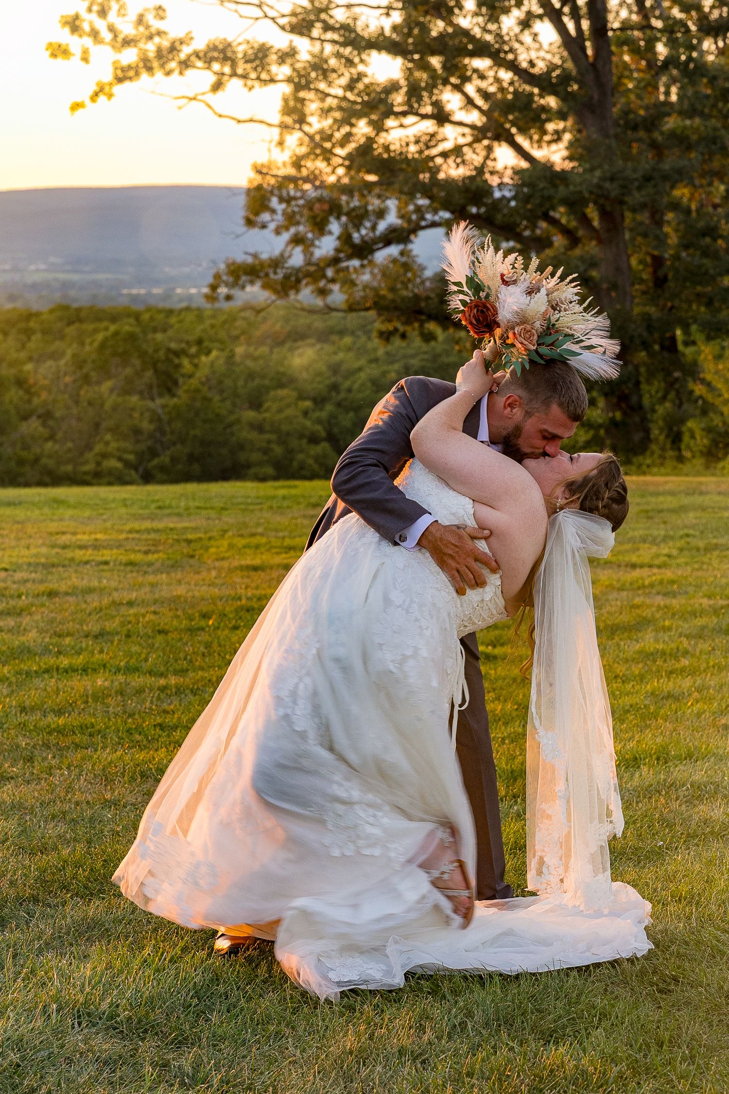 frederick maryland wedding photographer A romantic sunset dip kiss on a hilltop during golden hour.