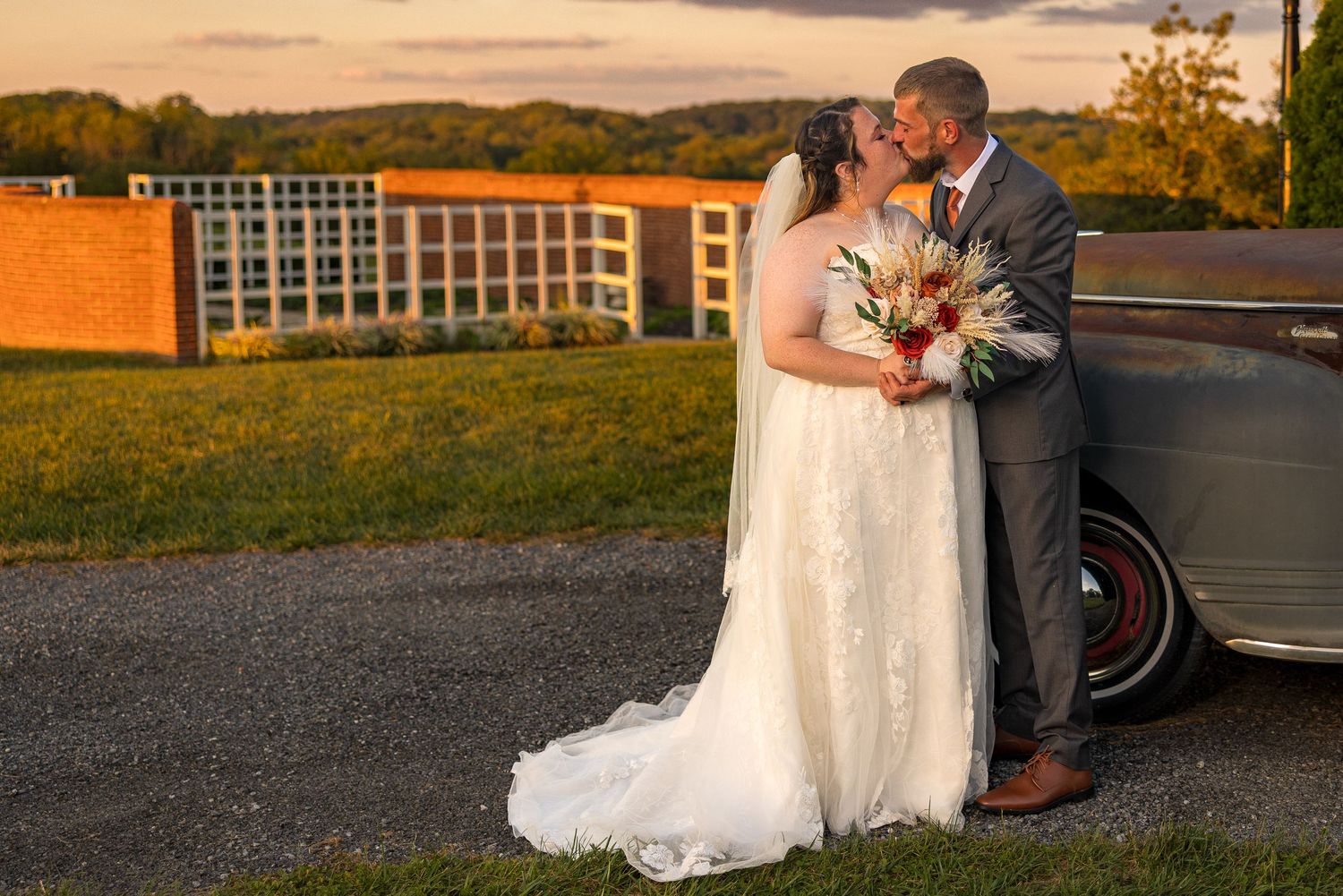 frederick maryland wedding photographer Newlyweds share a romantic moment at sunset with vintage architecture in background.
