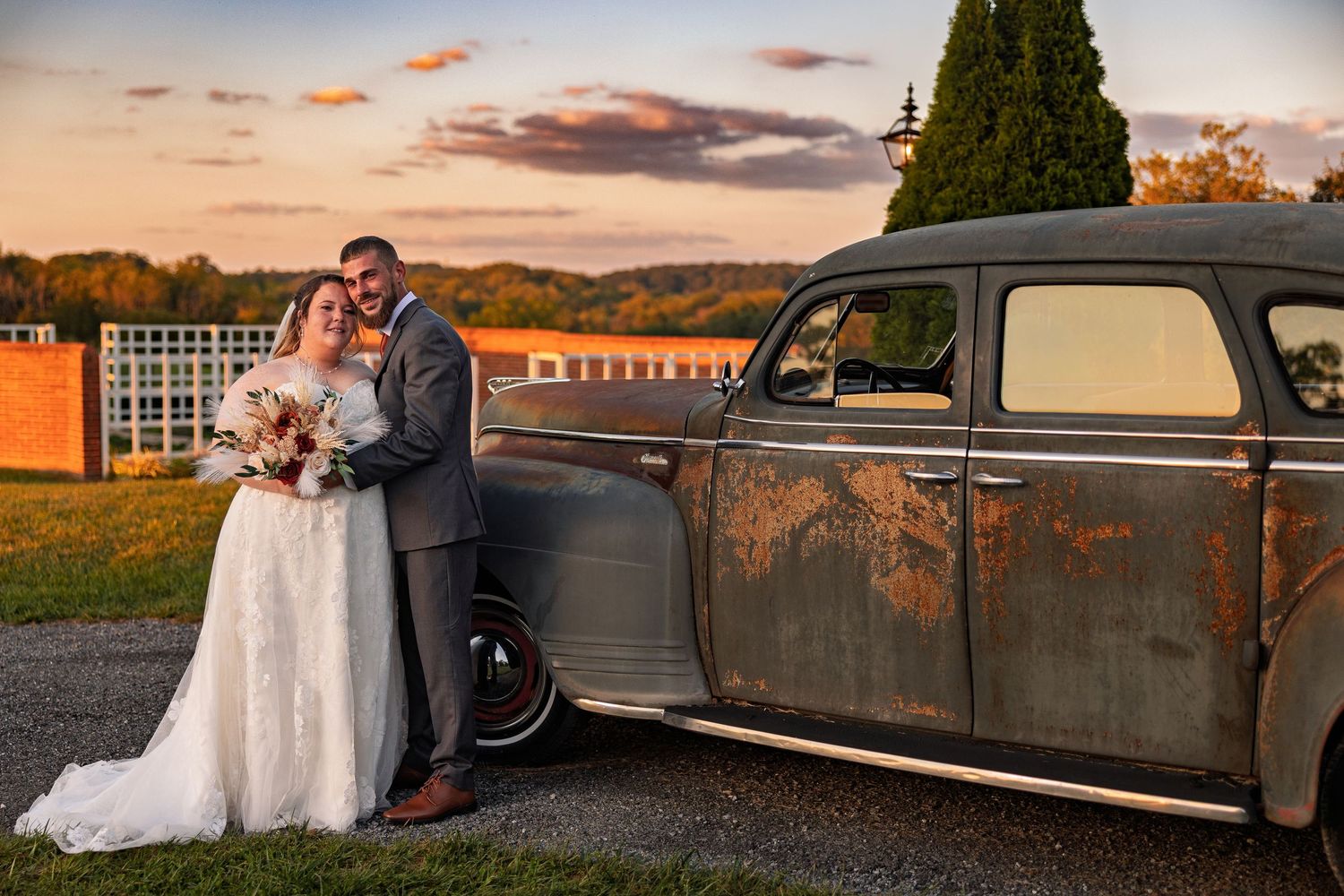 frederick maryland wedding photographer A romantic sunset portrait of newlyweds posing with a classic vintage car.