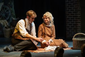theatre photography Brighton. an actress and actor sit on stage with a wicker basket in the show great expectations. wide angle shot