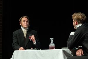 theatre photography Brighton. two actors sit on stage at a table in victorian costume in show great expectations
