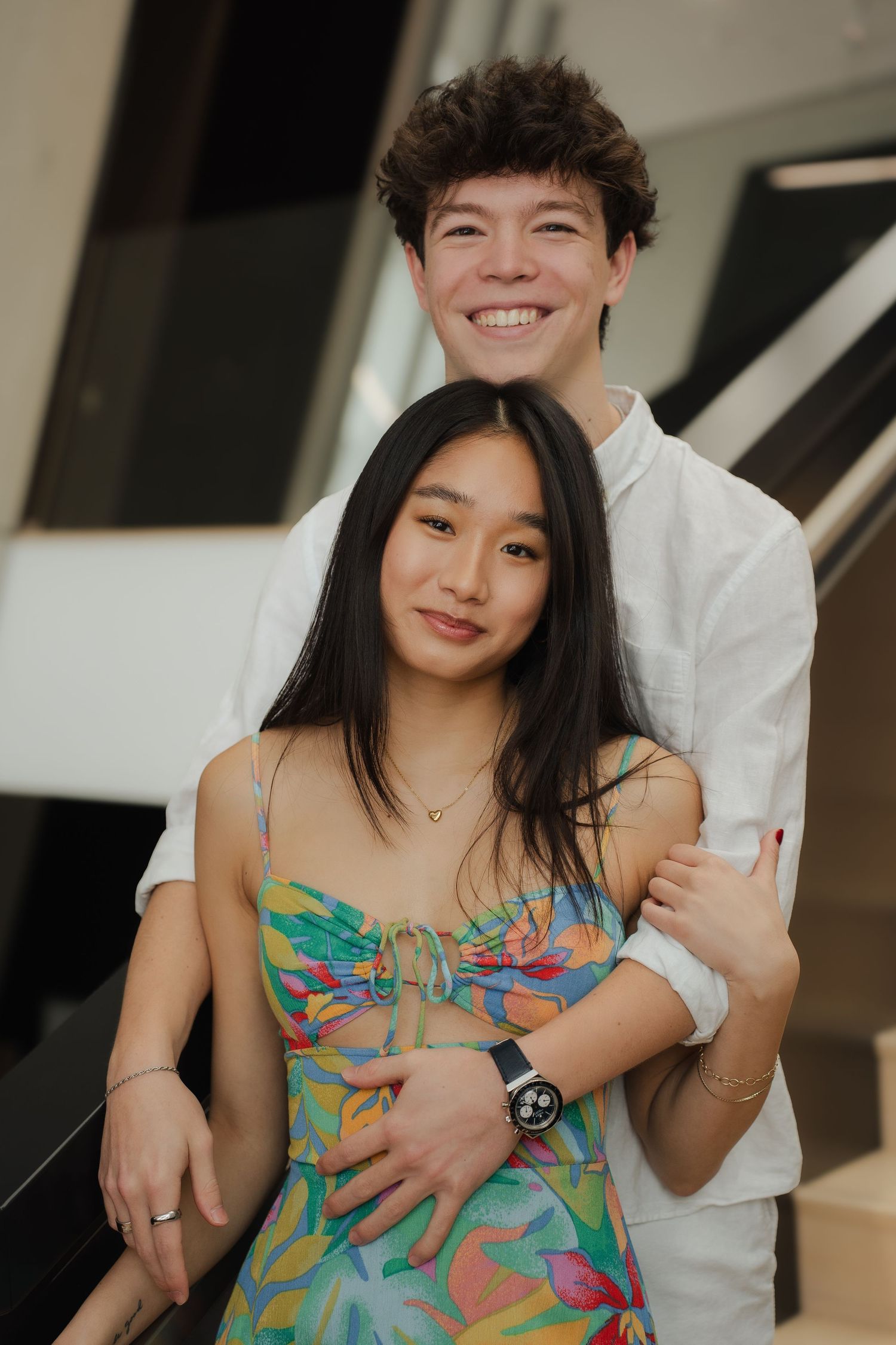 A romantic moment captured between two people, with one wearing a vibrant floral sundress.