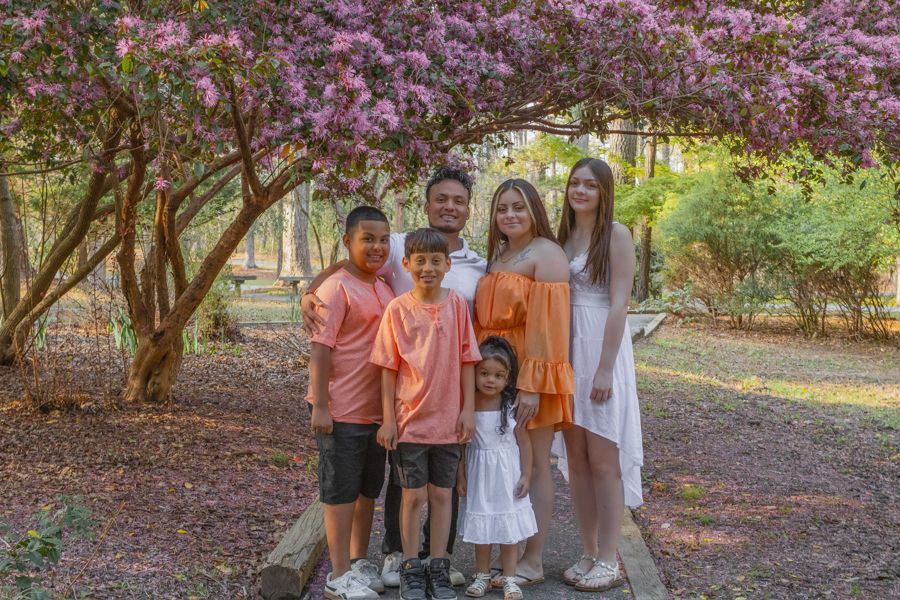 family on a path under a purple flowered tree in newport news park in newport news, virginia