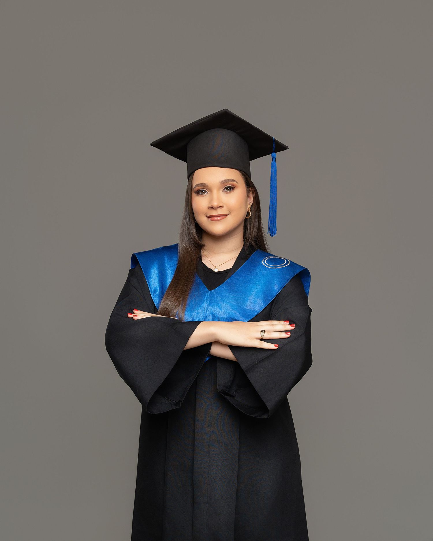 Graduate in cap and gown holds blue diploma folder in sequence of professional studio portraits against gray background.