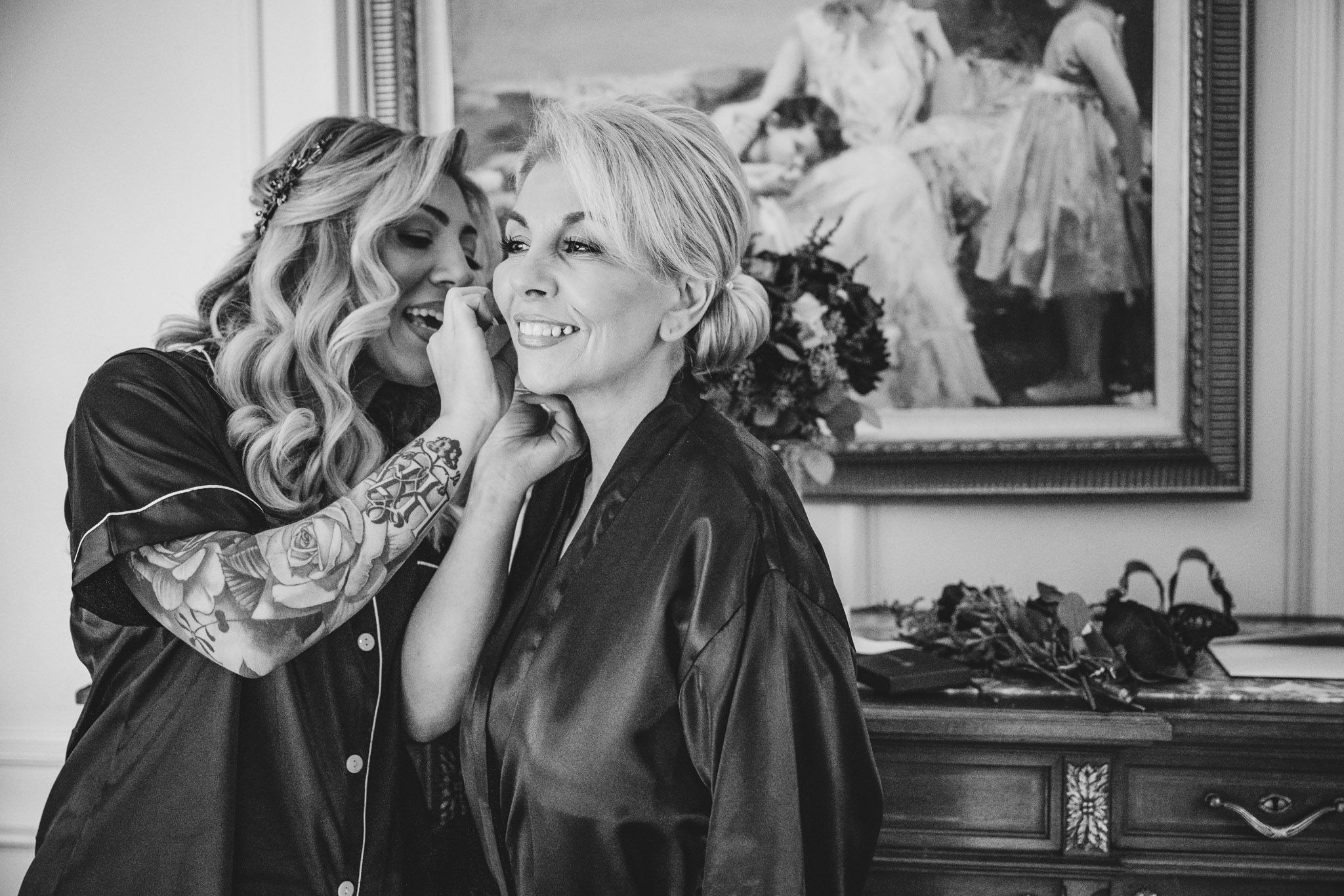 Wedding party getting ready in a room with elegant decor and framed artwork.