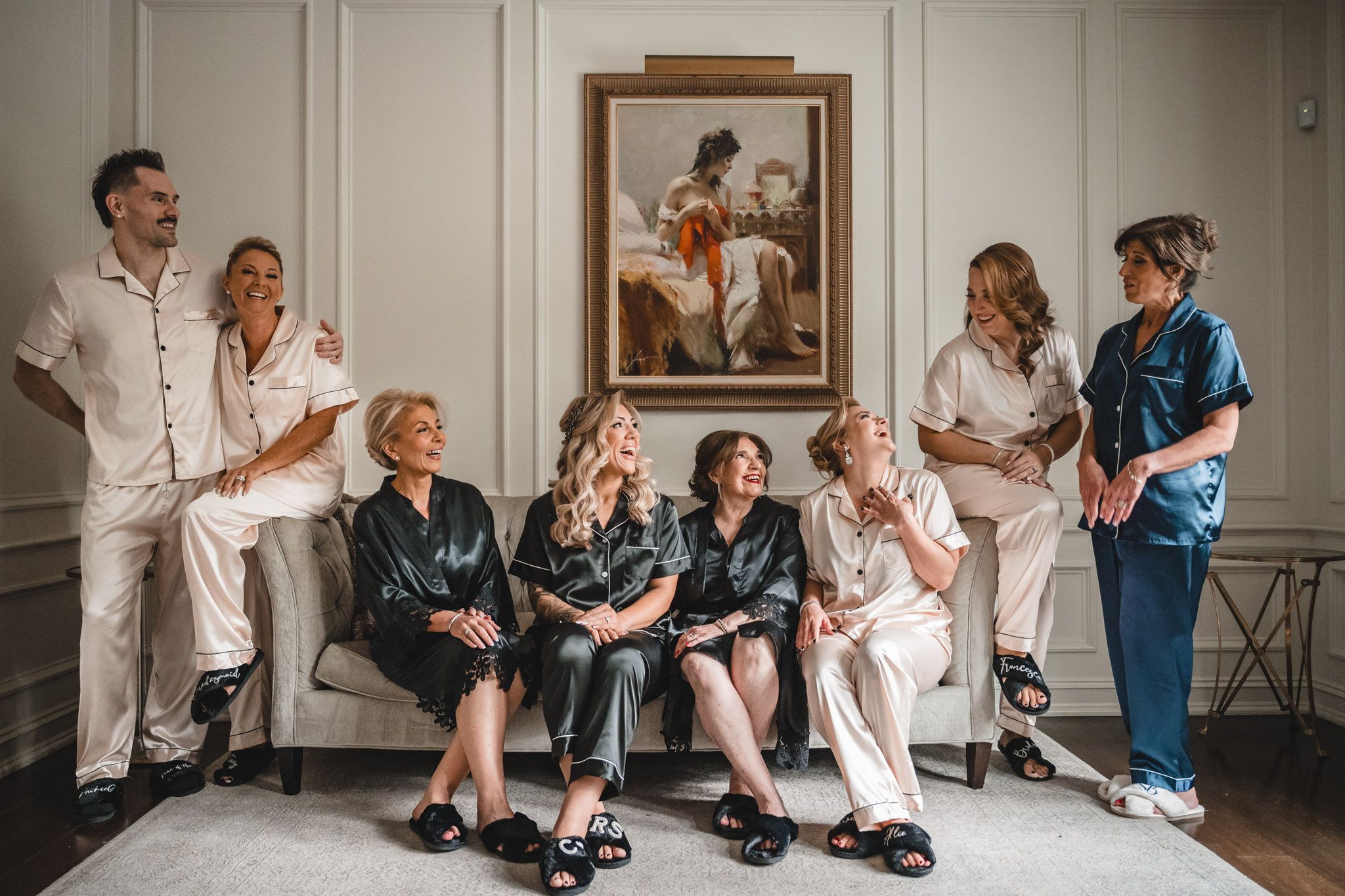 Playful wedding party in blue and white outfits posing together in an indoor setting.