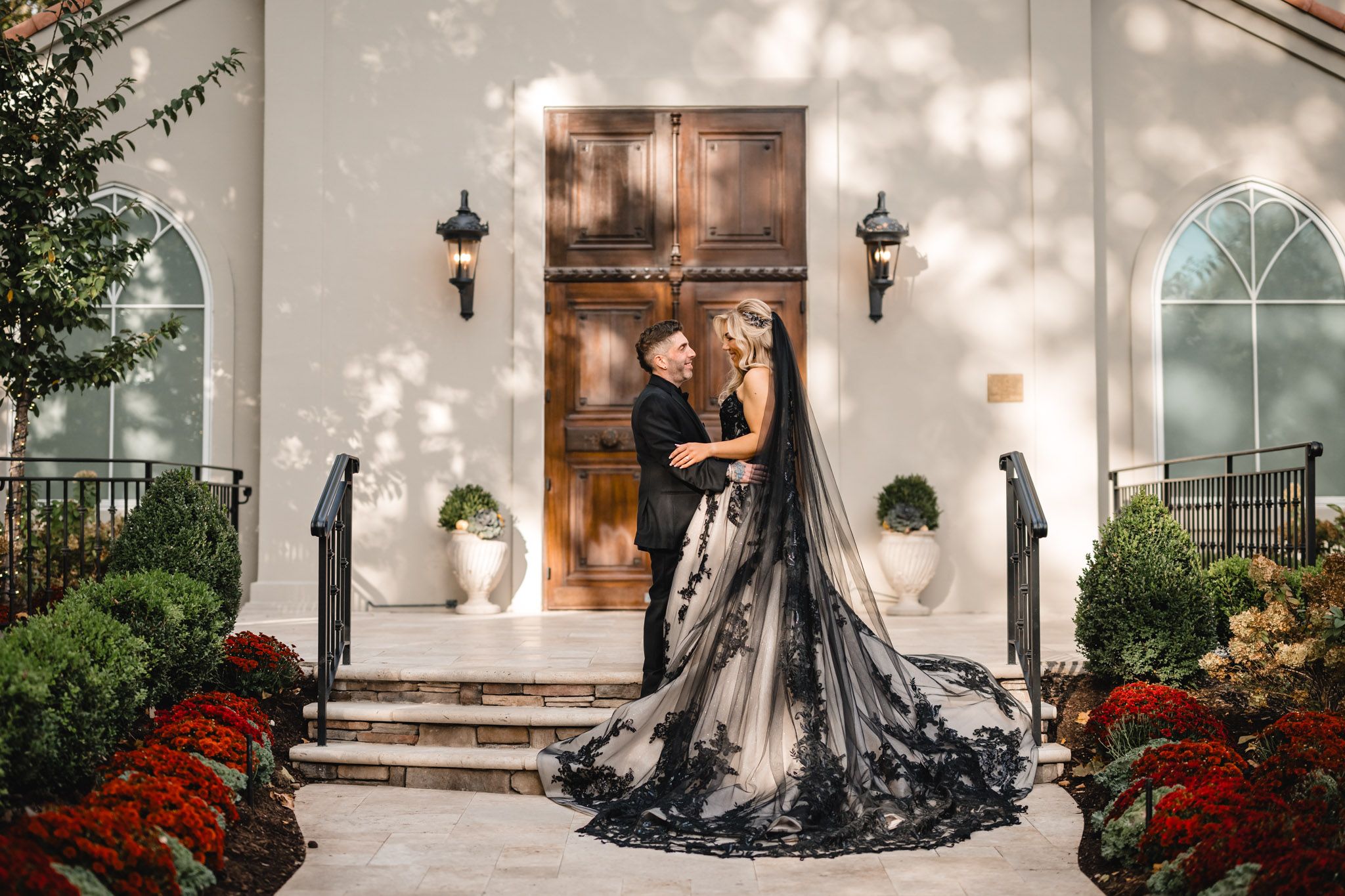 Dramatic black dress flowing on church steps with architectural details and autumn decor.