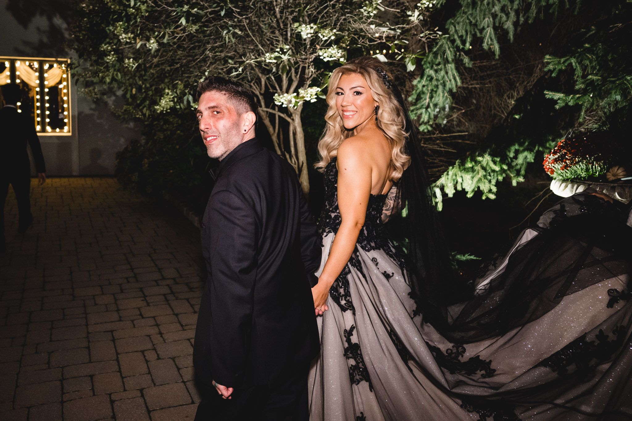 Evening outdoor wedding photos with dramatic lighting and elegant formal attire.
