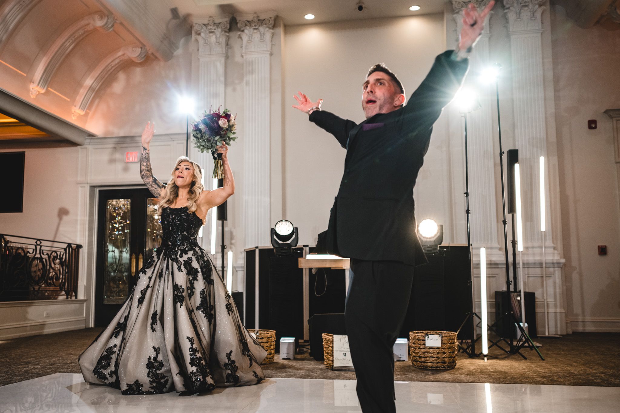 Celebration in an elegant white ballroom with dramatic lighting.