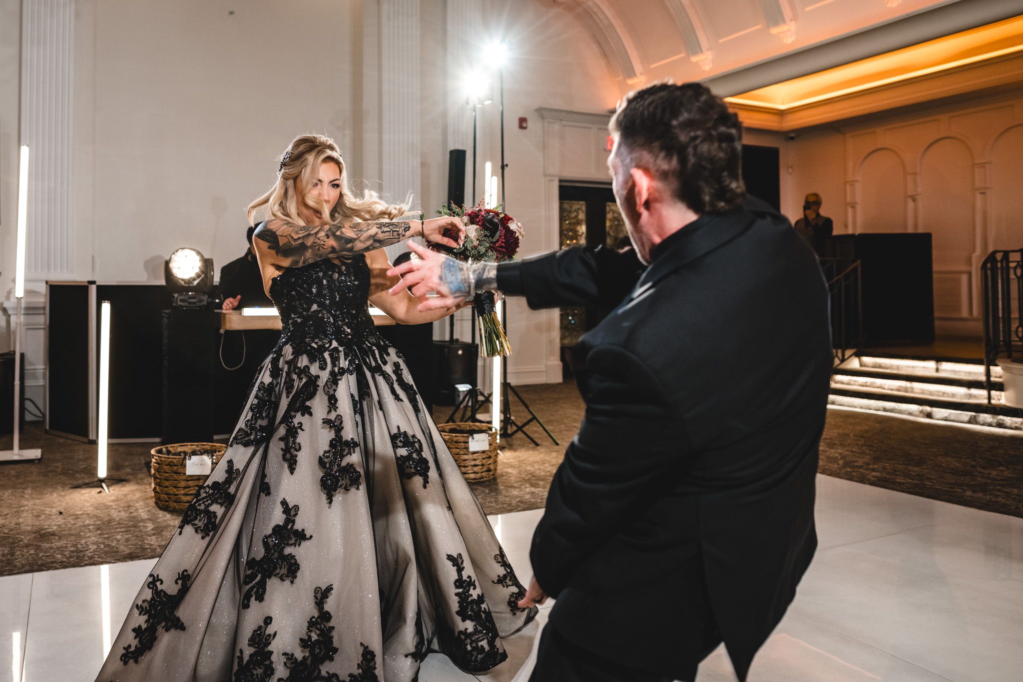 Couples dancing at an elegant wedding reception in a warmly lit ballroom.