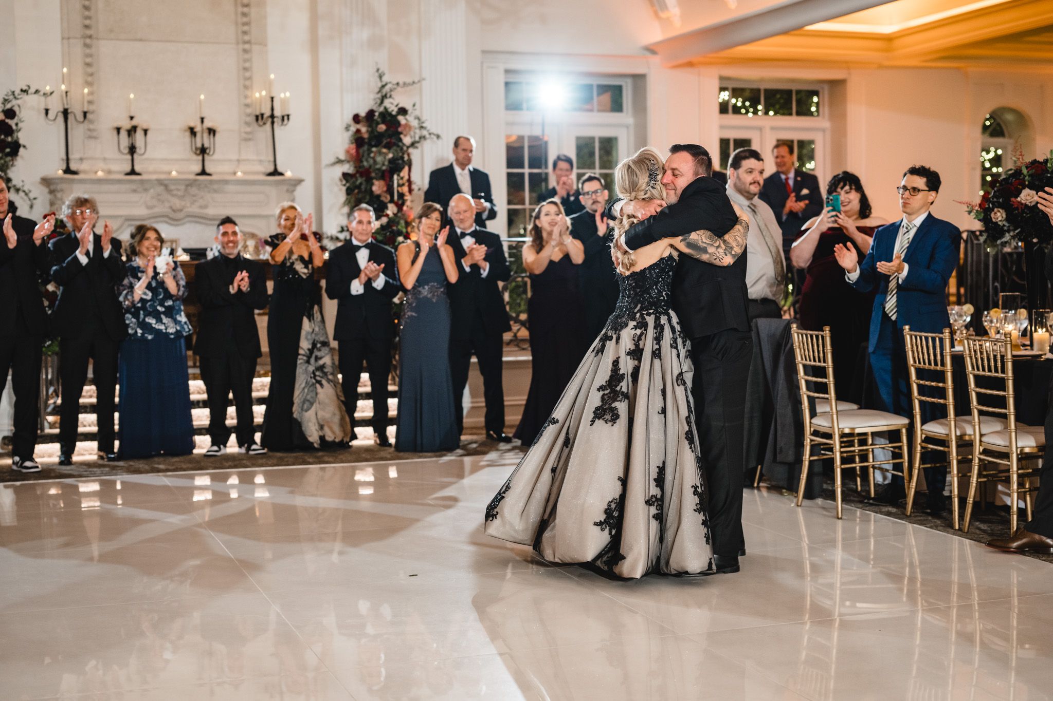 Panoramic view of a luxurious wedding reception with guests dancing and socializing.