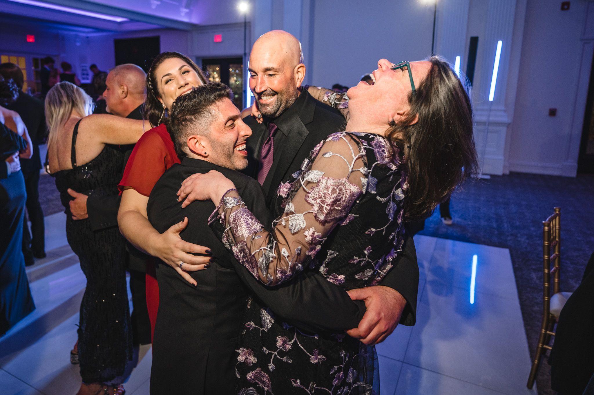 Wedding reception dance party with blue mood lighting and energetic atmosphere.
