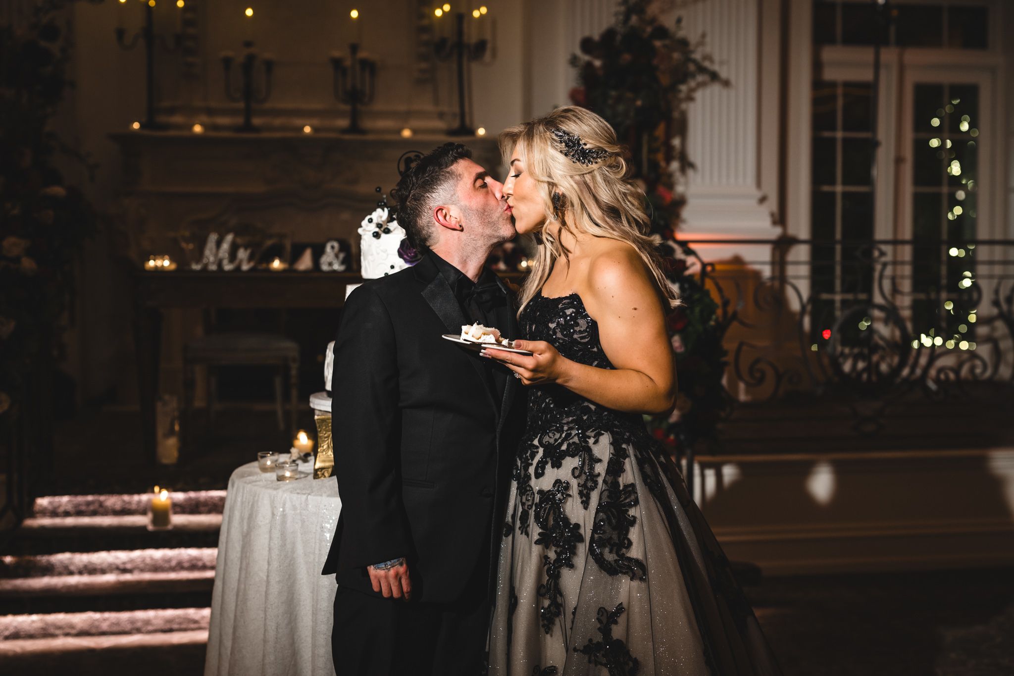 Couples dancing at an evening wedding reception with decorative lighting and chandeliers.