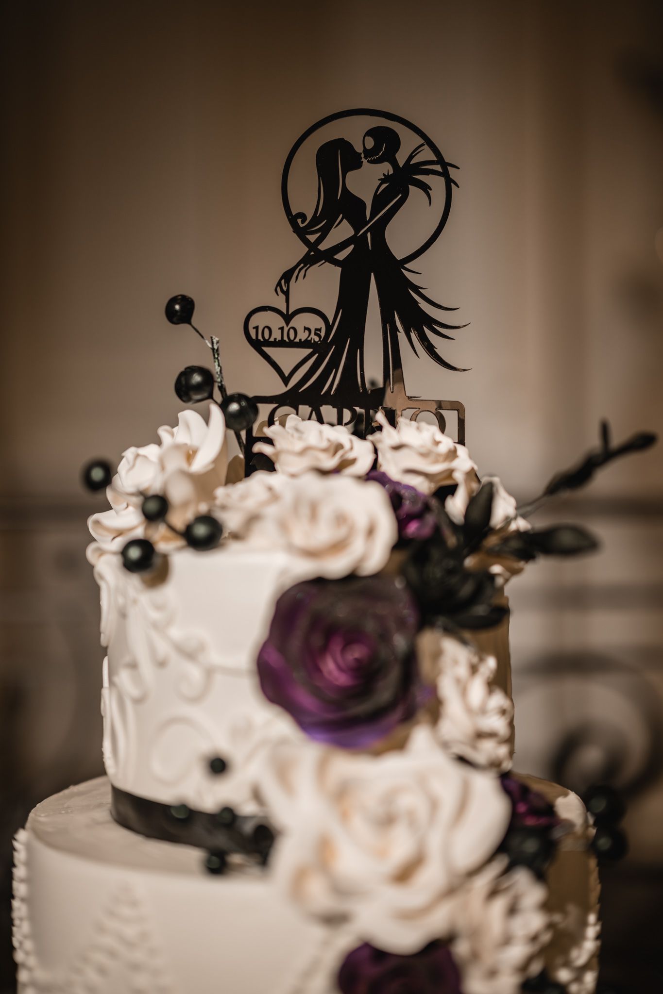 Wedding cake topper featuring silhouettes and delicate floral decorations.