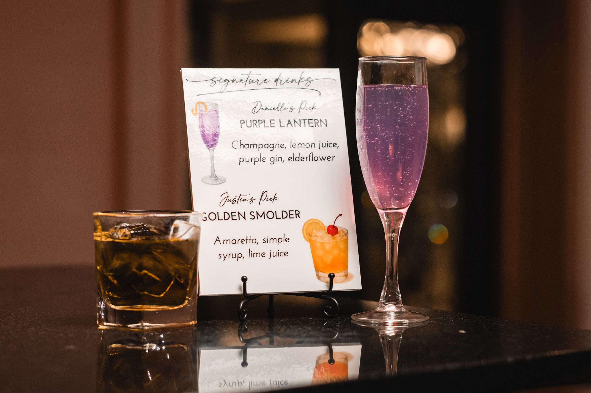 Signature cocktails and drink menu cards displayed on an elegant bar setup.