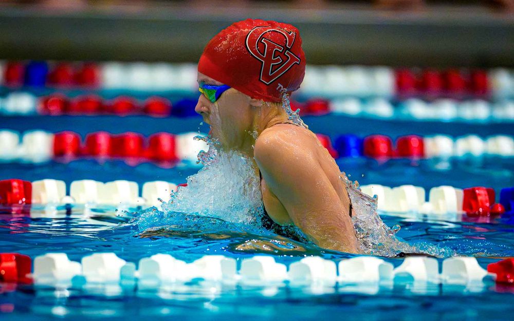 Cumberland Valley swimmer in red cap competing in a breaststroke event at the CV Natatorium during the Hershey meet.