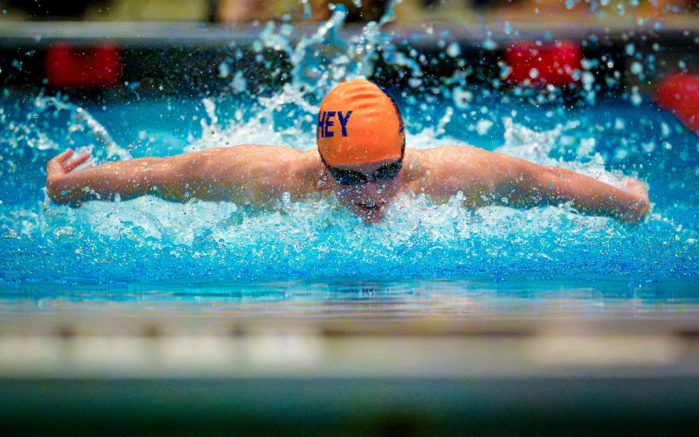 Hershey High School swimmer in orange cap racing butterfly with water splashing at the Keystone meet.