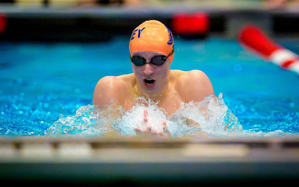 Hershey swimmer in orange cap competing in breaststroke during the Keystone swim meet against Cumberland Valley.