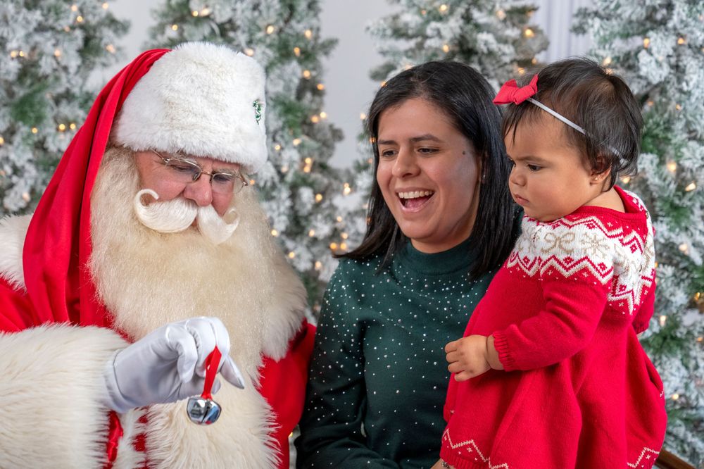 A festive Christmas photo session with Santa Claus in his traditional red suit against a snowy winter backdrop.
