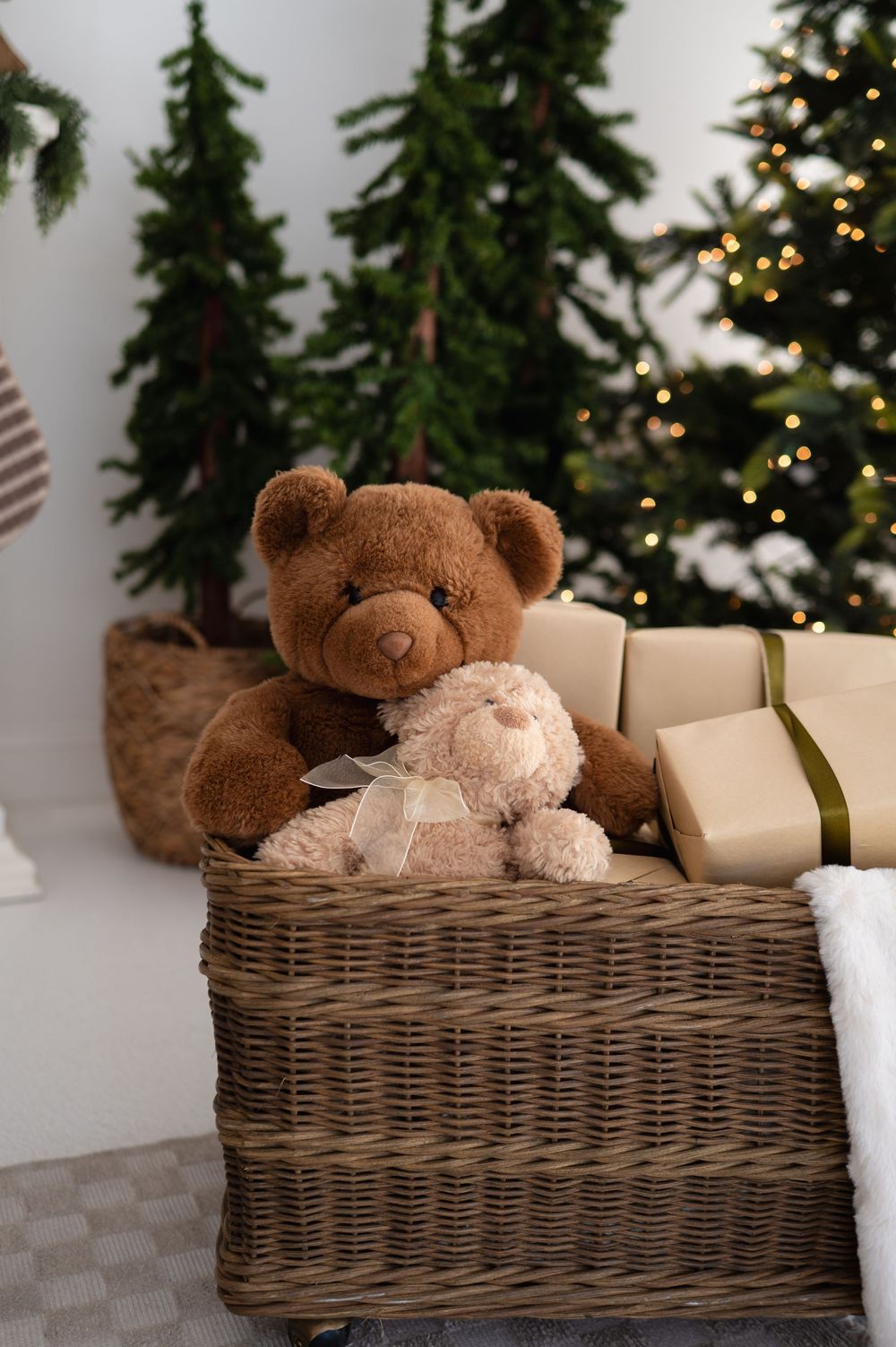 teddy bears in basket in front of small christmas trees at The Photo Space Christmas pop-up designed by B Del Bosque Photography