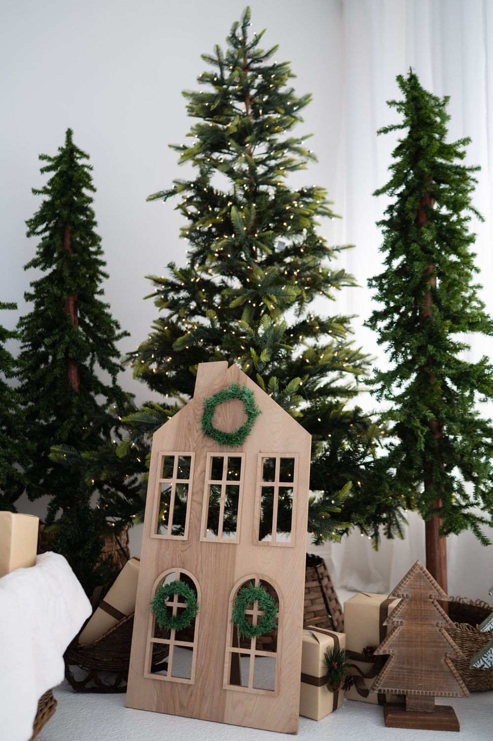 Christmas trees behind a wooden neutral christmast themed decor at The Photo Space Christmas pop-up designed by B Del Bosque Photography