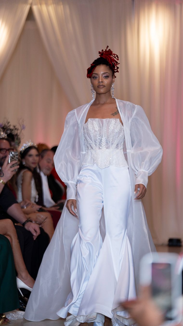 Collection of elegant white wedding dresses with puff sleeves displayed on runway at bridal fashion show.