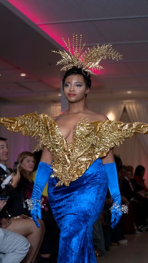 Royal blue velvet gown with gold metallic shoulder details on the catwalk.