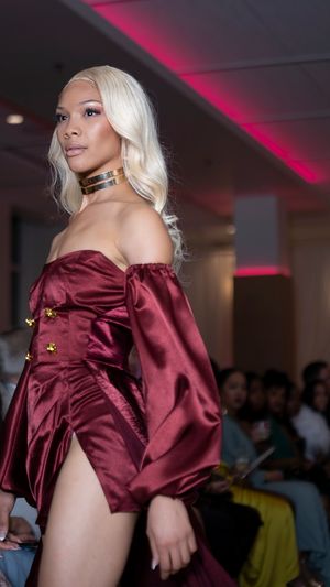 Burgundy satin mini dress with structured shoulders on display.