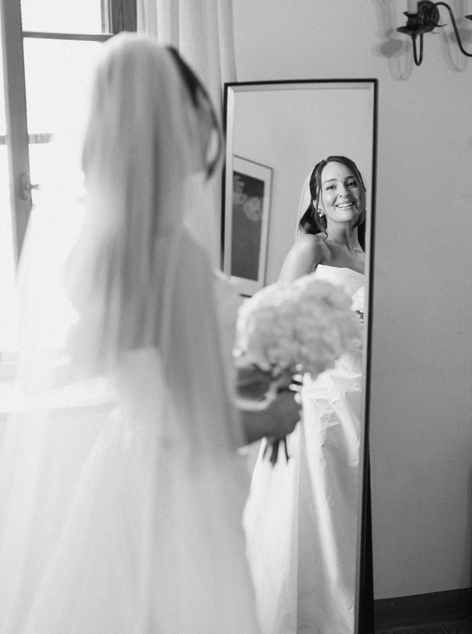 A series of black and white photos showing a bride getting ready in her wedding dress and veil.