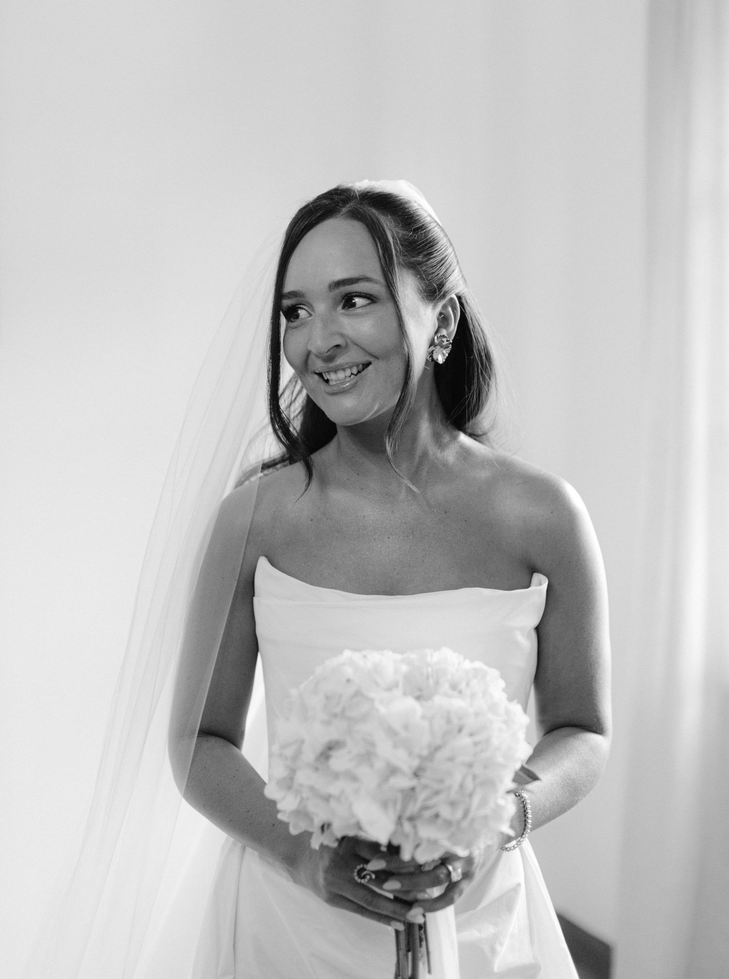 A sequence of candid black and white photos showing a joyful bride in her strapless wedding gown and veil.