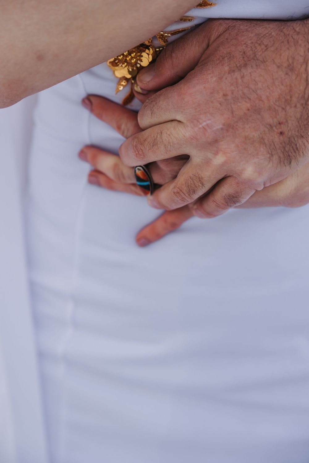 Close-up sequence of hands wearing ornate gold rings against a white background.