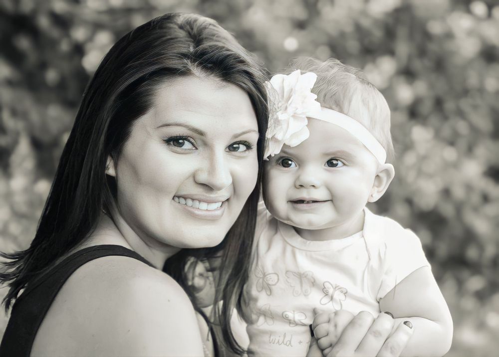 Joy filled black & white portrait of a mom and her baby with a white headband smiling outdoors. Wine Country - Napa, CA