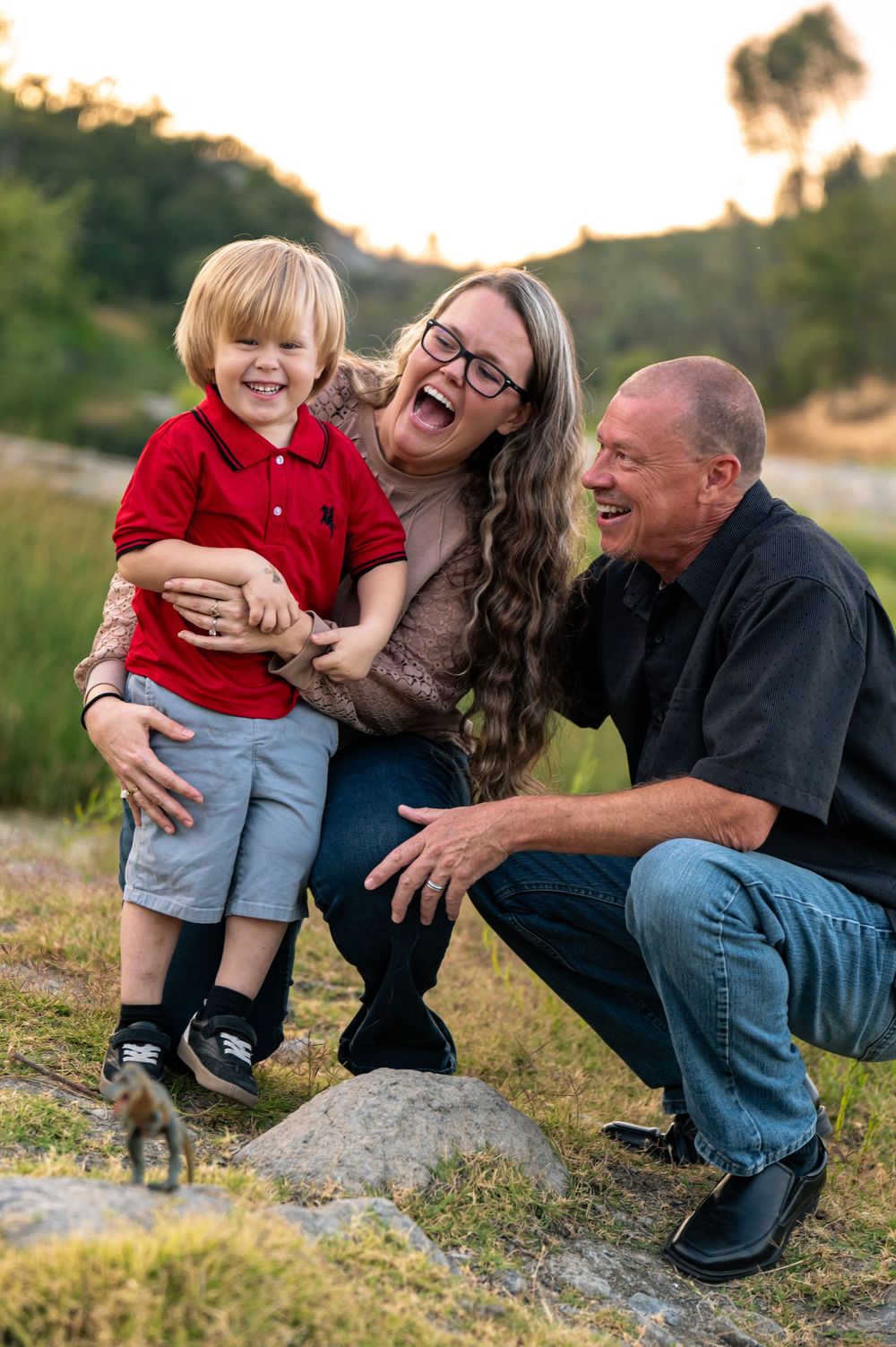 A vibrant photo of an adventurous joyful family moment captured outdoors on rocky lake side terrain during golden hour. Pope Valley, CA
