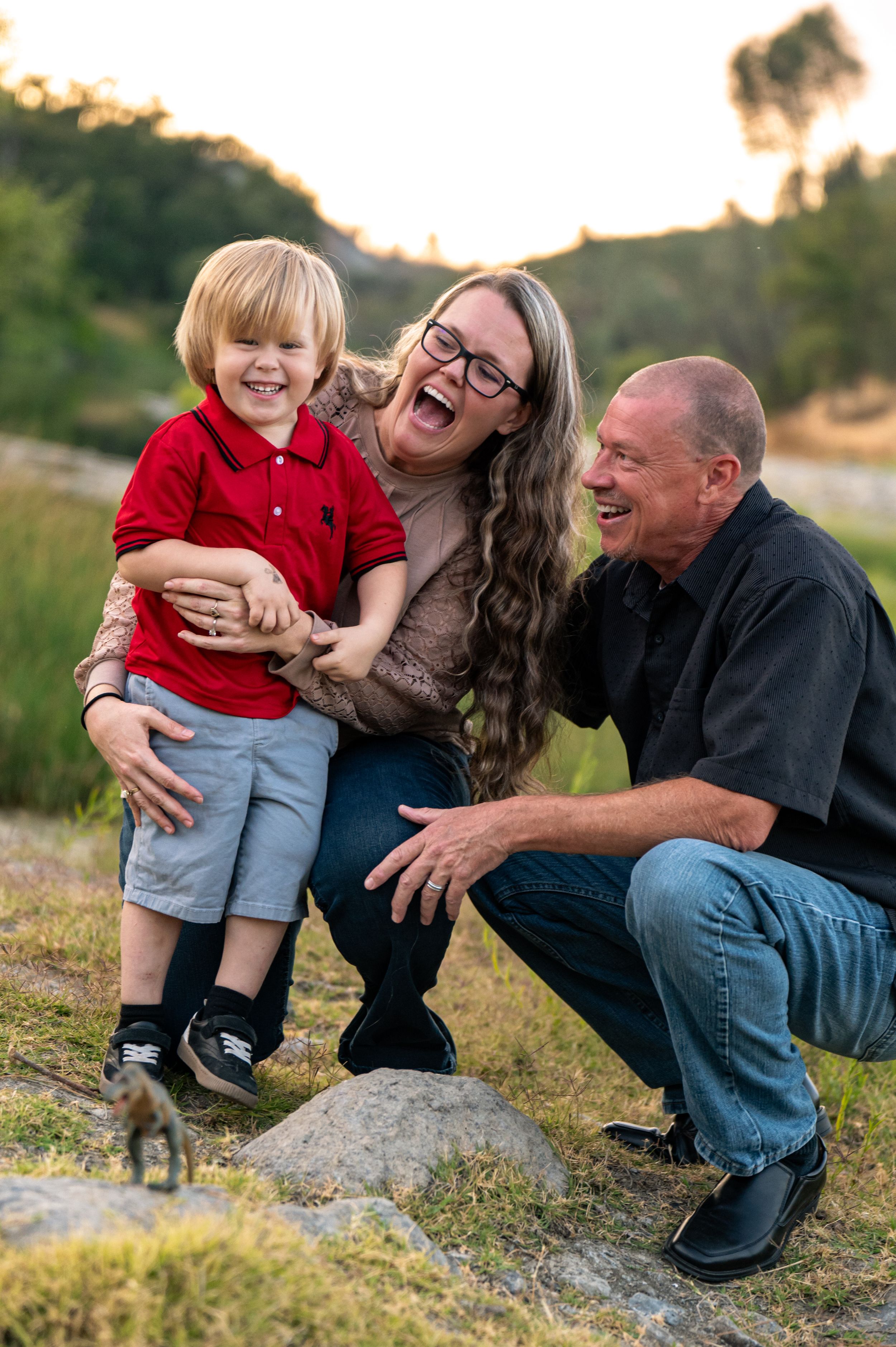 A vibrant photo of an adventurous joyful family moment captured outdoors on rocky lake side terrain during golden hour. Pope Valley, CA
