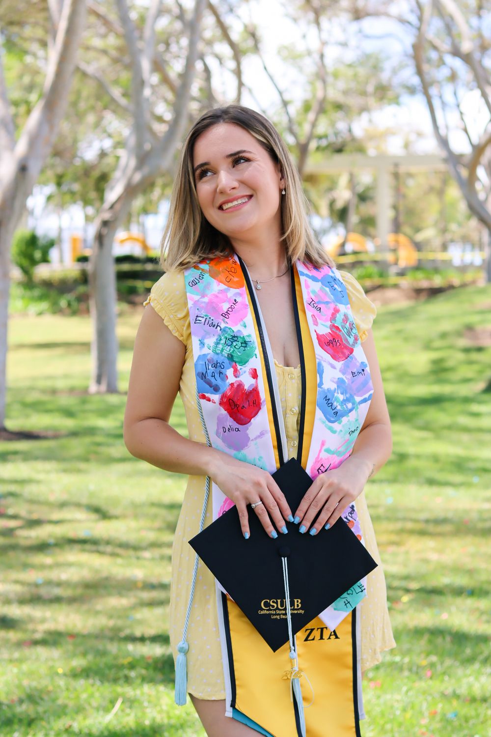 A series of graduation photos showing a person in a black top and yellow stole posing joyfully in a sunny park setting.