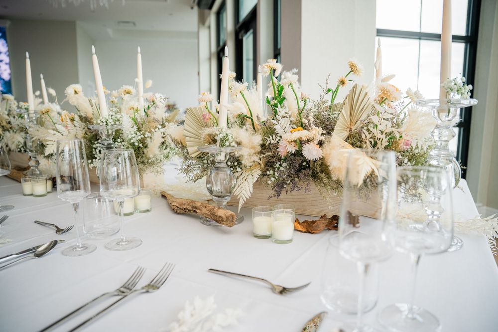 Elegant white and green wedding table settings with floral centerpieces and crystal glassware create a romantic atmosphere.