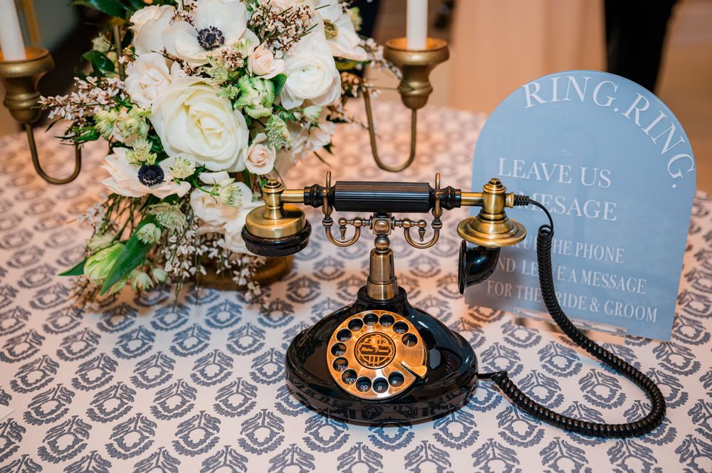 Elegant wedding reception table with black candelabras, gold accents, and delicate floral arrangements in a romantic setting.