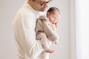 Dad holding newborn baby during newborn session in bishopdale studio