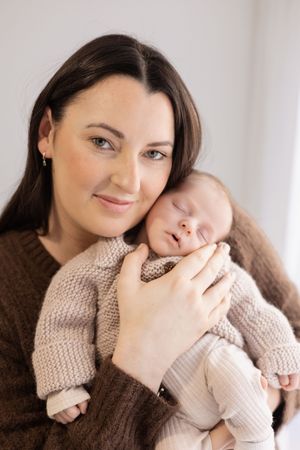 mum holding her baby during newborn session in the studio in Bishopdale.