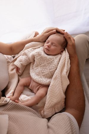 Studio newborn session, parents cradling baby in arms
