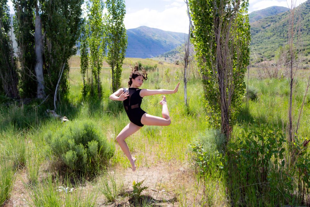 Contemporary dance movements captured in a series of poses among tall poplar trees and mountain scenery.