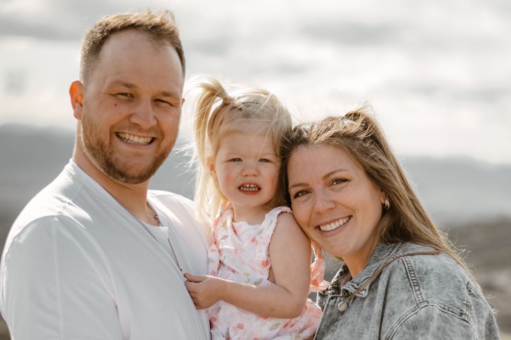 Family portrait session on desert cliff with mountains in background.