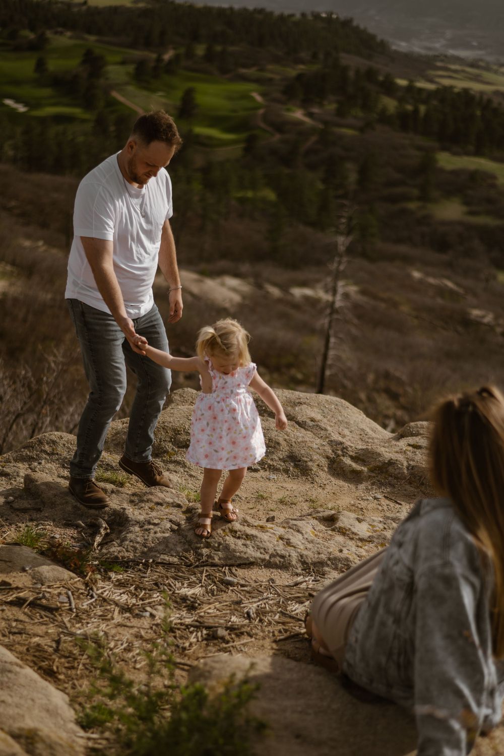Family explores rocky terrain together during outdoor adventure.