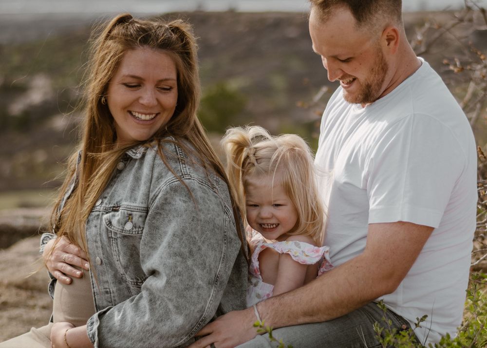 Candid family moments captured during outdoor photoshoot on rocky terrain.