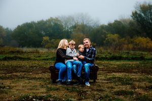 A series of candid outdoor family photos taken in a rustic field during autumn with fall foliage in the background.